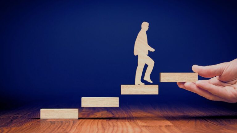 Person climbing wooden blocks symbolising career progression, guided support and executive coaching